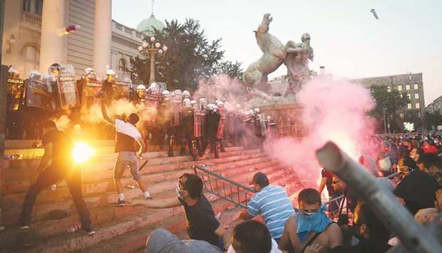 Protesters clash with police in Belgrade on Wednesday evening as violence erupted against a later-withdrawn weekend curfew.