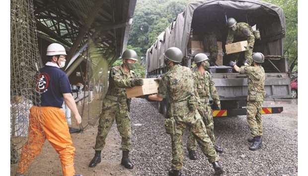 Members of Japan Self-Defence Forces unload relief supplies in the flood hit village of Kumamura, Kumamoto prefecture yesterday.