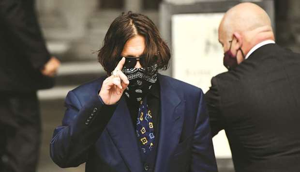 Actor Johnny Depp gestures as he arrives at the high court in London yesterday.