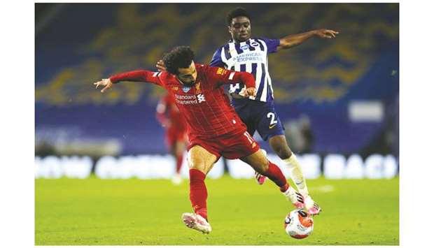 Liverpoolu2019s Mohamed Salah (left) vies for the ball with Brightonu2019s Lamptey during the Premier League in Brighton, southern England, on Wednesday. (AFP)