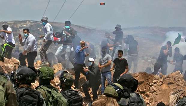 Palestinian demonstrators and Israeli forces clash during a protest against Jewish settlements and Israel's planned annexation of parts of the Israeli-occupied West Bank, in the town of Asira Shamaliya near the West Bank city of Nablus