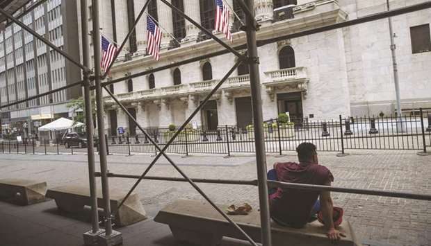 A person sits on a bench outside the New York Stock Exchange. Vanguard Group, the New York Stock Exchange and Nasdaq are pushing back on an escalating risk to their bottom lines: Threats from Capitol Hill and the Trump administration to dramatically curtail US investments in Chinese companies.