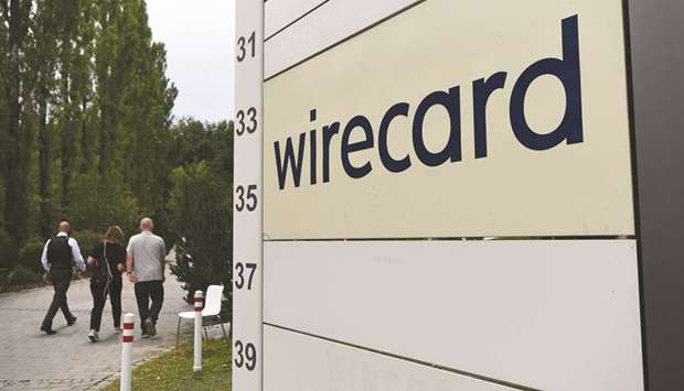 Visitors pass a sign at the entrance to the Wirecard headquarters in Munich. Once a darling of the fintech scene, the payments provider filed for insolvency in June after being forced to admit that u20ac1.9bn ($2.1bn) missing from its accounts likely did not exist.