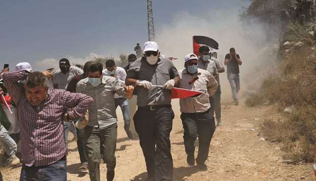 Palestinian protesters flee clashes with security forces during a protest against Jewish settlements and Israelu2019s planned annexation of parts of the occupied West Bank, in the town of Asira Shamaliya near the city of Nablus, yesterday.