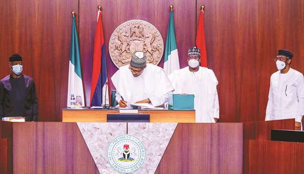 Nigerian President Muhamadu Buhari signs the revised 2020 budget in Abuja, yesterday.