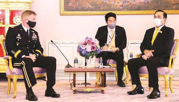 US Army Chief of Staff General James C McConville and Thailand Prime Minister Prayut Chan-o-cha, wearing face masks, speak during their meeting at Government House in Bangkok yesterday.