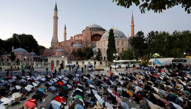 Muslims gather for evening prayers in front of the Hagia Sophia, after a court decision that paves the way for it to be converted from a museum back into a mosque, in Istanbul, yesterday.