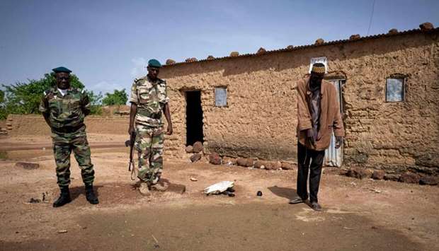 Boubou Sangare (R) shows Malian gendarmerie in Fana on June 30, 2020, the site where his brother's headless body was found a few weeks earlier