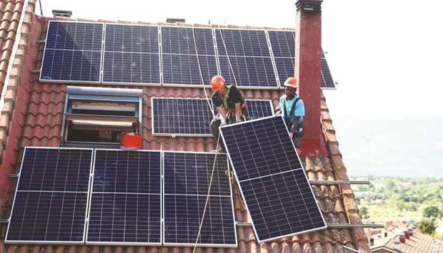 Workers of the installation company Alromar set up solar panels on the roof of a home in Colmenar Viejo, Spain.
