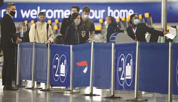 Passengers wearing face masks or covering due to the Covid-19 pandemic, queue at a British Airways check-in desk at Heathrow airport, west London, yesterday. The government yesterday revealed the first exemptions from its coronavirus quarantine, with arrivals from Germany, France, Spain and Italy no longer required to self-isolate