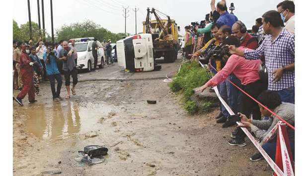 People stand next to an overturned vehicle which was carrying Vikas Dubey, accused of ordering the killing of eight policemen, near Kanpur, Uttar Pradesh, yesterday.