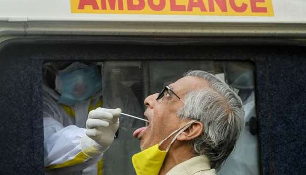 A state health worker sitting inside an ambulance collects a swab sample from a person testing for the Covid-19 in Kolkata, India