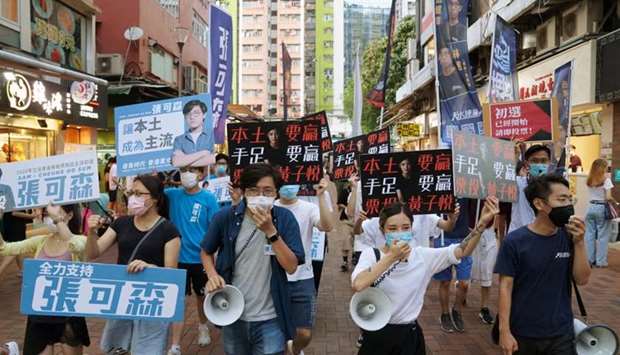 Sam Cheung Ho-sum and Wong Ji-yuet march on a street to campaign for the primary election aimed at selecting democracy candidates for the September election, in Hong Kong