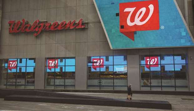 A pedestrian walks past a Walgreens Boots Alliance store in the Times Square area of New York. Deerfield, Illinois-based Walgreens said that it anticipates full-year adjusted earnings between $4.65 to $4.75 a share, including $1.03 to $1.14 a share of costs related to Covid-19. Analysts surveyed by Bloomberg were expecting $5.43 a share.