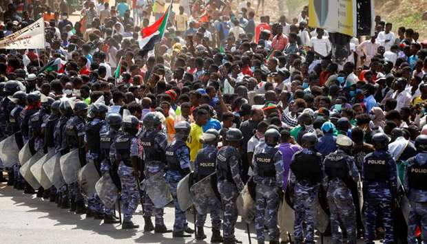 Riot police officers hold position against protesters near the Parliament buildings, as members of Sudanese pro-democracy protest on the anniversary of a major anti-military protest, in Omdurman, yesterday.
