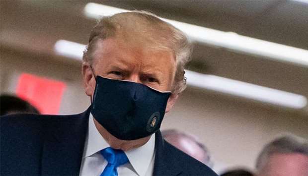 US President Donald Trump wears a mask as he visits Walter Reed National Military Medical Center in Bethesda, Maryland'