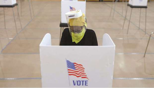 FILE PHOTO: Jocelyn Bush, a poll worker at the Edmondson Westside High School Polling site, cleans each station after a ballot is cast, during the special election for Marylands 7th congressional district seat, previously held by Republican Elijah Cummings (D-MD), in Baltimore, Maryland, US, on April 28.