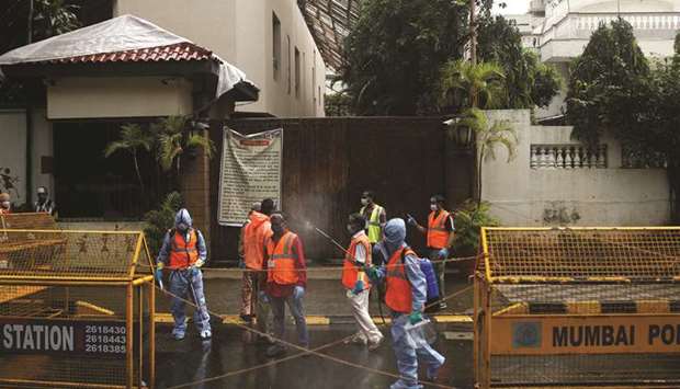 Municipal workers in personal protective equipment (PPE) wait to enter the residence of Bollywood actor Amitabh Bachchan to sanitise it yesterday.