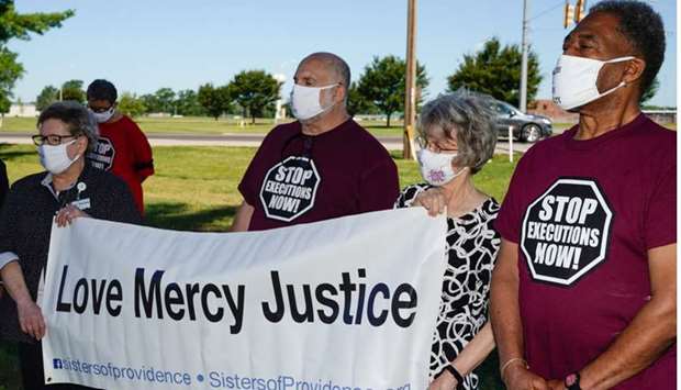 Individuals who oppose the death penalty gather outside the Federal Correctional Complex, Terre Haute, as a federal judge has momentarily prevented the execution Daniel Lewis Lee, who is convicted in the killing of three members of an Arkansas family in 1996, and would be the first federal execution in 17 years, in Terre Haute, Indiana.
