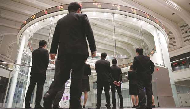 Visitors watch share prices at the Tokyo Stock Exchange. The Nikkei 225 closed up 2.2% to 22,784.74 points yesterday.
