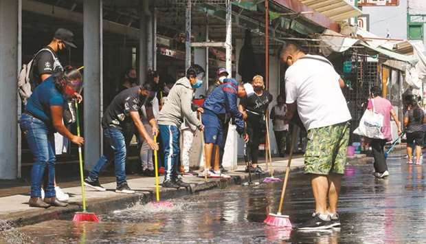Shopkeepers clean a street in Tepito neighbourhood in Mexico City, amid the new coronavirus pandemic.