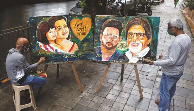 Artists create paintings depicting Bollywood actor Amitabh Bachchan, his son Abhishek Bachchan, his daughter-in-law Aishwarya Rai Bachchan and his granddaughter Aaradhya, after they tested positive for the coronavirus disease, in Mumbai yesterday.