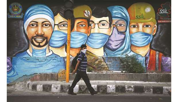 A man walks past a mural of frontline workers in the fight against the coronavirus in New Delhi yesterday.