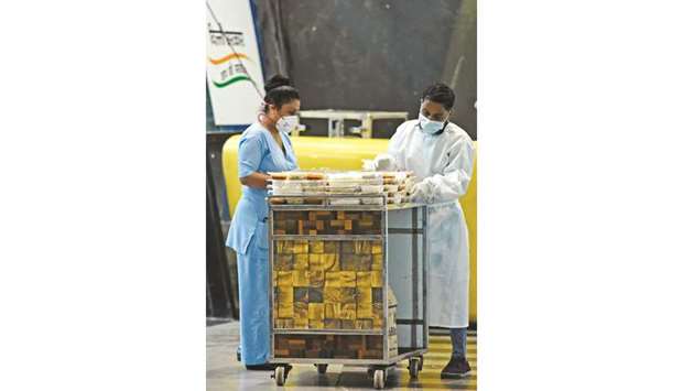 Attendants arrange food packets for patients outside a ward at the Commonwealth Games (CWG) Village sports complex, temporarily converted into Covid-19 care centre, in New Delhi yesterday.
