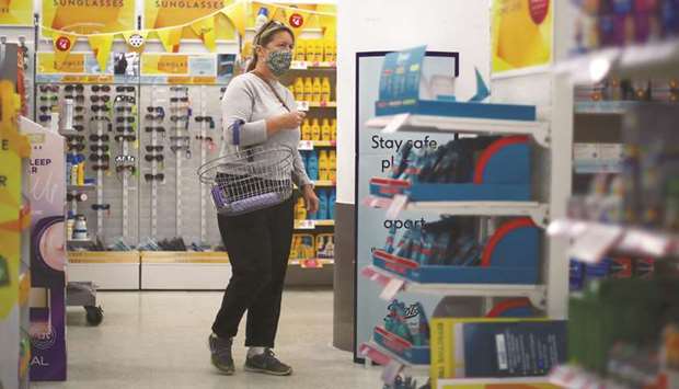A woman wears a protective face mask while shopping in London yesterday.