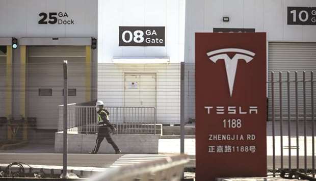 A worker walks past gates at the Tesla Inc Gigafactory in Shanghai. Tesla needs to succeed in China if it wants to dominate the world of electric cars u2013 especially in a post-virus world. To do that, Elon Musk is turning to a battery engineer who once helped Apple extend the life of its MacBook laptops.