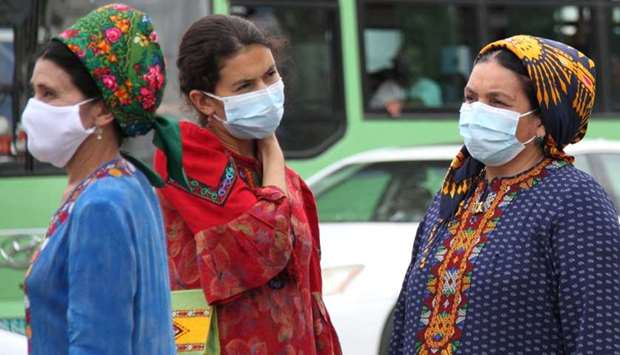 Women wearing protective face masks, used as a preventive measure against the spread of the coronavirus disease, are seen at a bus stop in Ashgabat, Turkmenistan