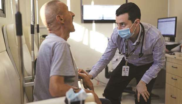 Vinicius Molla, a haematologist and volunteer of the clinical trial of Oxford Covid-19 vaccine, examines a patient at a consulting room in Sao Paulo, Brazil.