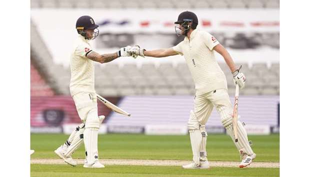 Englandu2019s Ben Stokes (left) celebrates his half-century with Dom Sibley on the first day of the second Test against West Indies at Old Trafford in Manchester yesterday. (Reuters)