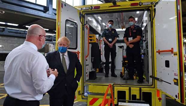 Britain's Prime Minister Boris Johnson talks with CEO London Ambulance Service Garrett Emmerson as he visits headquarters of the London Ambulance Service NHS Trust, amid the spread of the coronavirus disease, in London, Britain July 13