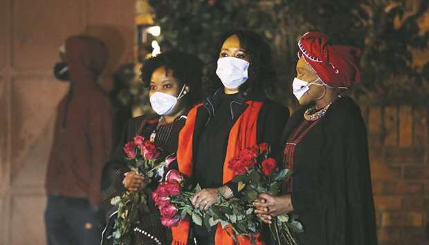 Mourners are seen as the funeral procession carrying the body of Zindzi Mandela, daughter of former South African president and liberation hero Nelson Mandela, passes her home in Soweto, yesterday.