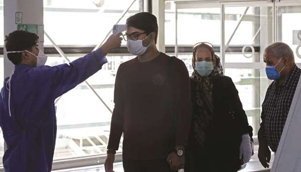 An airport worker checks the body temperature of incoming passengers as part of Covid-19 coronavirus pandemic precaution, upon arrival at the Iranian capital Tehranu2019s Imam Khomeini International Airport, yesterday.