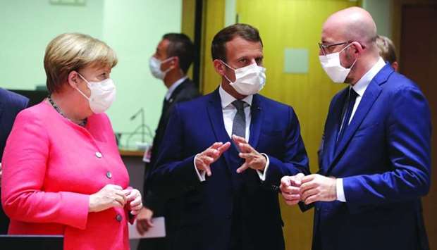 Germany's Chancellor Angela Merkel, French President Emmanuel Macron and European Council President Charles Michel talk at the start of the first face-to-face EU summit since the coronavirus disease (Covid-19) outbreak, in Brussels yesterday.