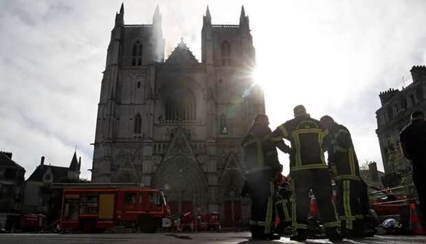 French firefighters gather at the scene of a blaze at the Cathedral of Saint Pierre and Saint Paul in Nantes, France