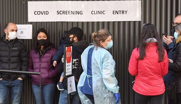 A medical worker (C) speaks to people queueing outside a Covid-19 coronavirus testing venue at The Royal Melbourne Hospital in Melbourne on July 16.