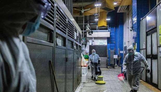 Food and Environmental Hygiene Department (FEHD) contractors take part in a cleaning and disinfection of Pei Ho Street Market in the Sham Shui Po district of Hong Kong