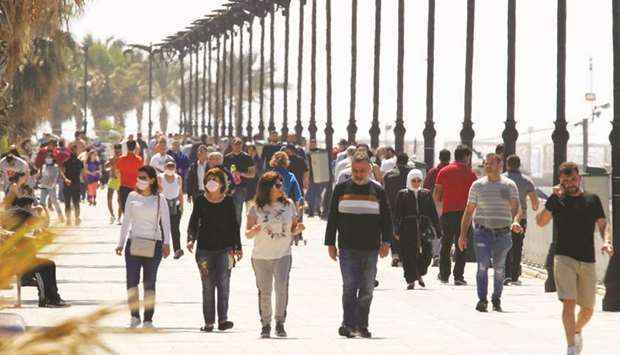 People walk along Beirutu2019s seaside corniche (file). The IMF warned Lebanon on Monday that attempts to lower losses from the financial crisis could only delay recovery.