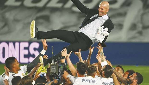 Real Madrid players toss coach Zinedine Zidane in the air after winning the La liga title on Thursday. (AFP)
