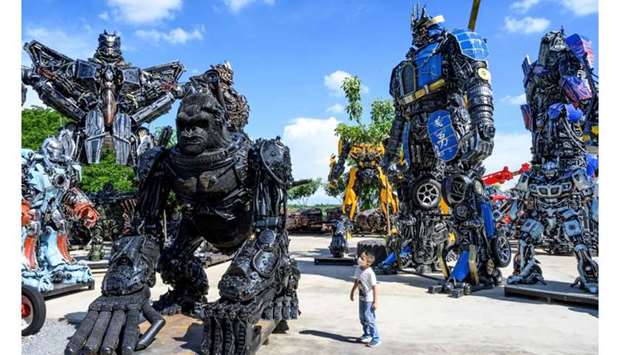 A child looking at a figure of King Kong in front of life-sized sculptures of characters from the \"Transformers\" film franchise, all made of scrap metal parts, at the Ban Hun Lek museum in Ang Thong, some 100km north of Bangkok.