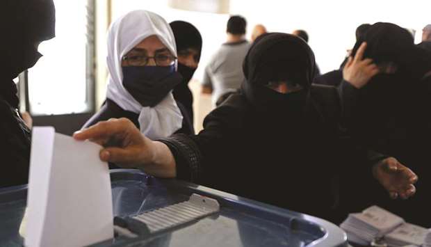 People cast their votes inside a polling station during the parliamentary elections in Douma, in the eastern suburbs of Damascus, yesterday.