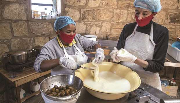 Assistant cheesemaker Jeanet Mapula Mokwena (left) prepares fig-filled scamorza cheese at the dairy of South African cheesemaker Marietjie Crowther (right) in Clarens in the small lab-turned-hut of Noahu2019s Cheese.