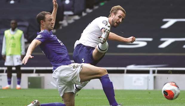 Tottenham Hotspuru2019s Harry Kane (right) scores past Leicesteru2019s Jonny Evans during the Premier League match yesterday. (AFP)