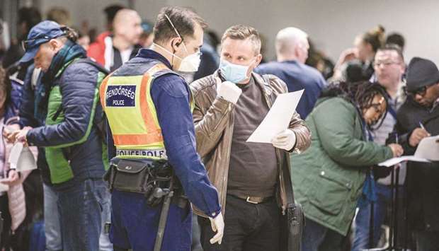 A police officer (left) and an airline passenger wear protective face masks as they talk during a passenger health screening at Debrecen International Airport in Debrecen, Hungary. According to the United Nations World Tourism Organisation (UNWTO), the decline in international tourism for the rest of 2020 could translate to $910bn u2014 $1.2tn in lost revenue for the aviation industry.