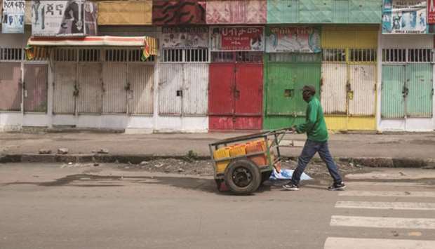 A man pushes a hand-cart past closed shops following protests in Addis Ababa, Ethiopia, yesterday.