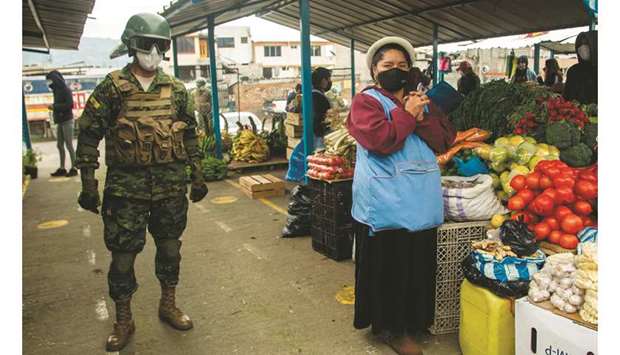 An Ecuadorean soldier patrols a market as part of an inter-institutional operation alongside the National Police and the municipality to enforce lockdown restrictions amid the new coronavirus pandemic at Guamani u2013 a Covid-19 high contagion sector u2013, in southern Quito.