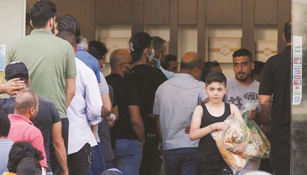 People queue to buy bread at a bakery in Beirut on June 27. As accelerating poverty fuels anger, despair and fear of a social explosion, efforts by Lebanonu2019s ruling elite to salvage the country from a financial meltdown with IMF help seem to be going in reverse.